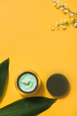 Seçici odak ile papatya çiçekli papatya yüz kremi kavanoz. Pembe bir arka plan, düz yatıyordu, kozmetik görünüm üst. Kopya alanı