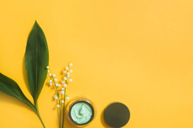 Seçici odak ile papatya çiçekli papatya yüz kremi kavanoz. Pembe bir arka plan, düz yatıyordu, kozmetik görünüm üst. Kopya alanı