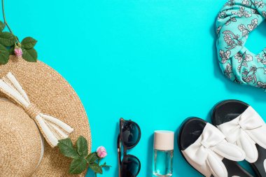 üstten görünüm yaz aksesuarları, hasır şapka, güneş gözlüğü, çiçek ve selfie mavi bir arka plan üzerinde sopa. Hafta sonu ve bırakın. Düz yatıyordu. kopya alanı.