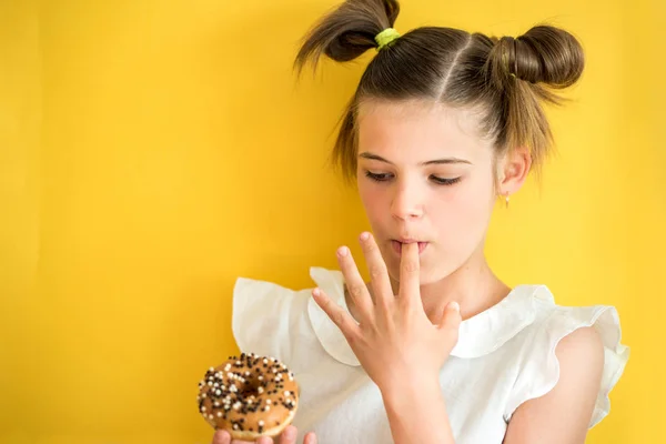 Όμορφη Έφηβος Κορίτσι Τρώγοντας Ένα Ντόνατ Γλείφει Ένα Δάχτυλο Συναισθηματικά — Φωτογραφία Αρχείου
