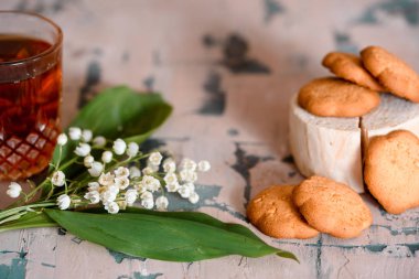 bir fincan çay, fındık, leylak ahşap bir masa üzerinde buket.