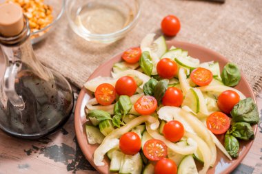 Gri doku arka plan üzerinde mavi plaka bez peçete ile bahar yaz diyet salata çilek, salatalık, yeşil alan salata ve yoğurt nane sosu ile servis.