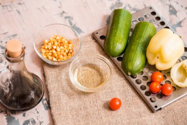 Gri doku arka plan üzerinde mavi plaka bez peçete ile bahar yaz diyet salata çilek, salatalık, yeşil alan salata ve yoğurt nane sosu ile servis.