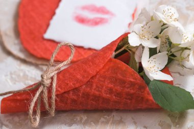 Dondurma külahı pembe bir arka plan üzerinde güzel çiçek. Kırmızı dudaklar kağıt üzerinde aşk kartpostal öp. Beyaz yasemin