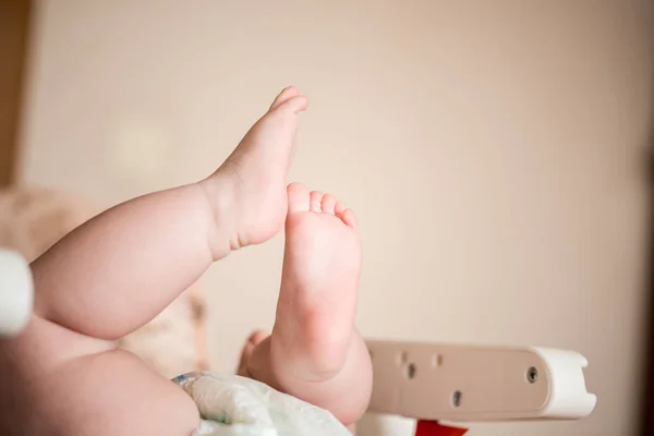 脚三月的婴儿 浮肿的高跟鞋 他躺着 抬起双腿 — 图库照片