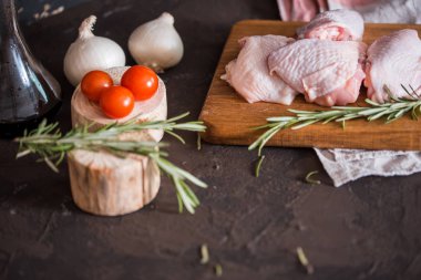 Tavuk ızgara için baharatlar, bitkiler, domates, mantar görünümü koyu arka plan üzerinde top. Çiğ et tavuk yemek pişirmek için. Lezzetli dengeli gıda kavramı.