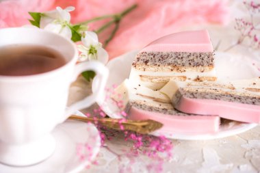 Çaydanlık ve hafif bir arka plan masaya bardakta tatlı pembe gül fincan kek