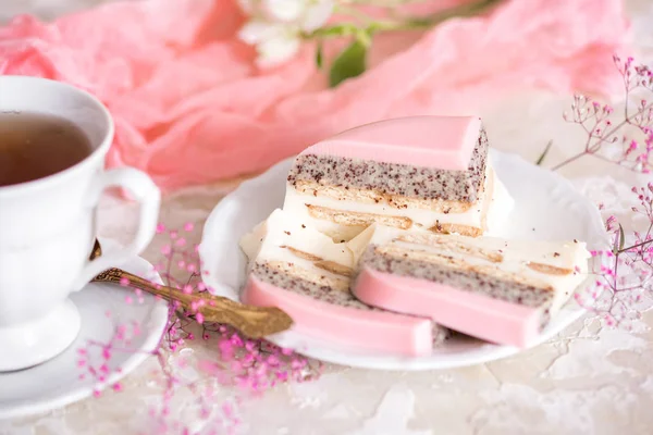 Çaydanlık ve hafif bir arka plan masaya bardakta tatlı pembe gül fincan kek