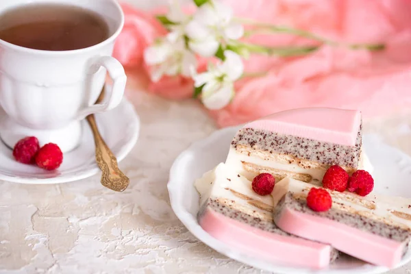 Çaydanlık ve hafif bir arka plan masaya bardakta tatlı pembe gül fincan kek