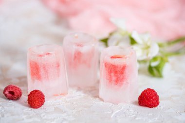 bir bardak buz, kırmızı bir içki, bir soğuk içecek ahududu kiraz ve çilek ile.