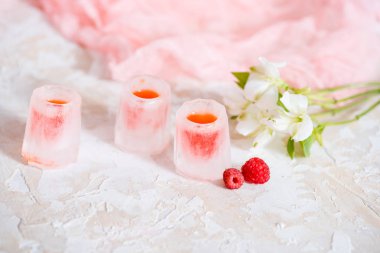 bir bardak buz, kırmızı bir içki, bir soğuk içecek ahududu kiraz ve çilek ile.