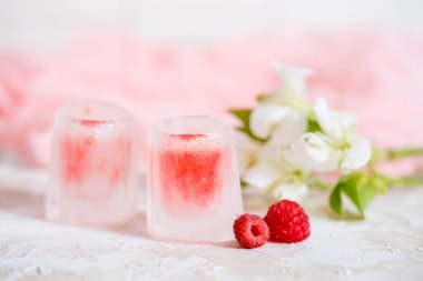 bir bardak buz, kırmızı bir içki, bir soğuk içecek ahududu kiraz ve çilek ile.