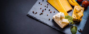 Peynir mavi peynir, brie, üzüm, incir, armut, tatlım, kraker, trüf sert peynir ile plaka kurutulmuş meyve ve fındık beyaz masada. Üstten görünüm. Uzun geniş afiş.