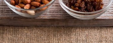 Kaseler ile Kuru üzüm, fıstık ve ahşap masa üzerinde. İki bardak bir tepsi, kumaş peçete, keten arka plan. Üstten görünüm. Uzay kopyalayın. Senin yazıt için bir yer. Uzun geniş afiş.