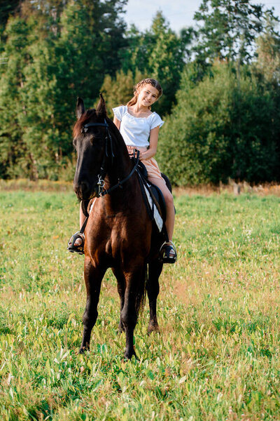 Picture of young pretty girl riding horse.