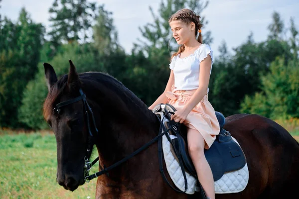 Picture of young pretty girl riding horse.