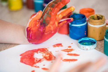 küçük kız ve erkek elleri renkli boya boyalı.