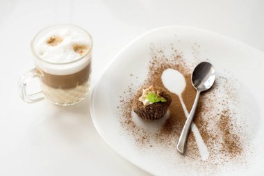 Tarçın ile bir pasta. Şeffaf bir fincan kapuçino