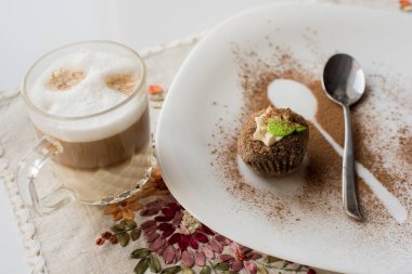 Tarçın ile bir pasta. Şeffaf bir fincan kapuçino