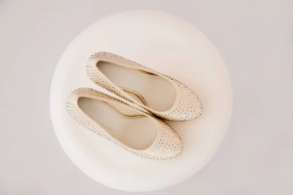 Beautiful bridal accessories for brides during fees. Dressing table, pink shoes with glass stones