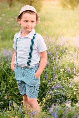 Mutlu çocuk alanında. Gülüyor ve gülümsüyor. bir diş. Mavi çim ve çiçek nehir su yakın. Yaz bitti, yakında sonbahar.