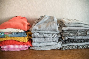 Kırmızı turuncu ve sarı renkli parlak yığını giyim gri karşı. Seçim ve bireysellik kavramı