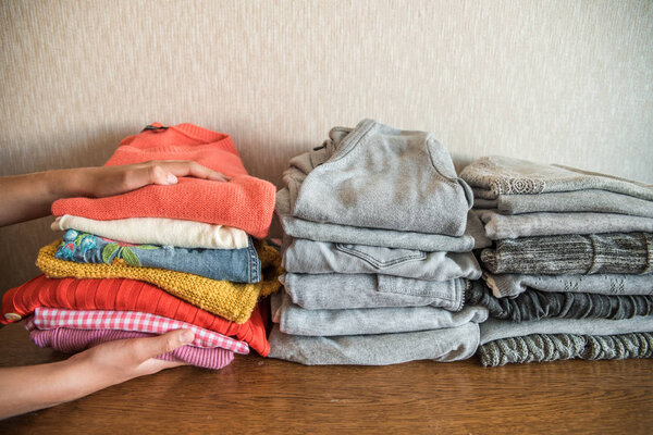 Red orange and yellow bright stack of clothes against the gray. The concept of choice and individuality