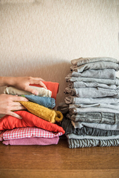 Red orange and yellow bright stack of clothes against the gray. The concept of choice and individuality