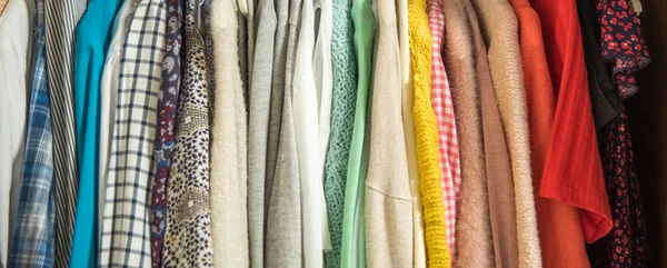 Uzun banner. Farklı elbise askıları kapatın. Çok renkli elbise ve kazak.
