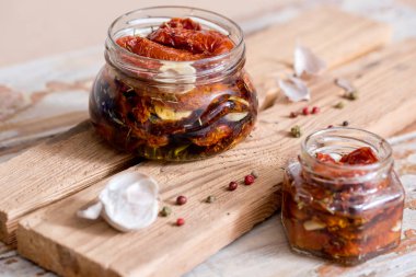 Kurutulmuş domates kekik ve deniz ile eski ahşap arka plan üzerinde bir cam kavanoza bir zeytinyağı tuz. Kırmızı biber ve sarımsak.