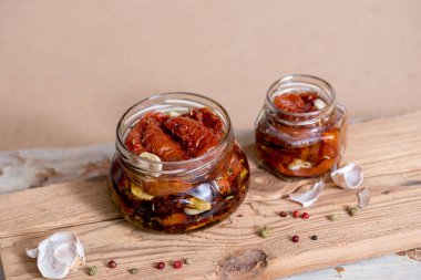 Kurutulmuş domates kekik ve deniz ile eski ahşap arka plan üzerinde bir cam kavanoza bir zeytinyağı tuz. Kırmızı biber ve sarımsak.