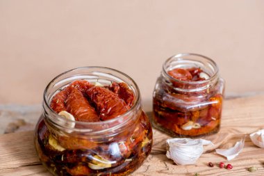 Kurutulmuş domates kekik ve deniz ile eski ahşap arka plan üzerinde bir cam kavanoza bir zeytinyağı tuz. Kırmızı biber ve sarımsak.