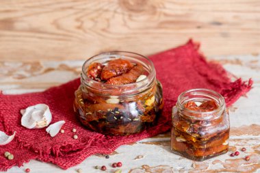 ahşap kase hizmet yağda kuru domates. Kırmızı biber ve sarımsak.