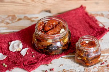 ahşap kase hizmet yağda kuru domates. Kırmızı biber ve sarımsak.