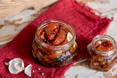 ahşap kase hizmet yağda kuru domates. Kırmızı biber ve sarımsak.