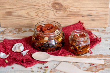 ahşap kase hizmet yağda kuru domates. Kırmızı biber ve sarımsak.