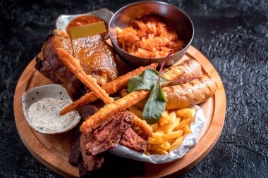 Fıçı bira köpüklü soğutulmuş bardak soğuk tavuk kanadı lezzetli sıcak gevrek ev yapımı taze kızarmış plakalı servis, dilimlenmiş domuz eti Saussage, patates, soğan ve peynir