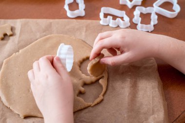 Çocuk el hamur yapmak ve ev yapımı gingerbread çerezleri Noel için pişirin. Gingerbread bir kalp, bir zeus, Noel topları ve hayvan şeklinde. Merry christmas ve yeni yıl kavramı