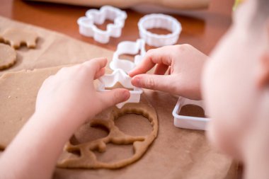 Çocuk el hamur yapmak ve ev yapımı gingerbread çerezleri Noel için pişirin. Gingerbread bir kalp, bir zeus, Noel topları ve hayvan şeklinde. Merry christmas ve yeni yıl kavramı