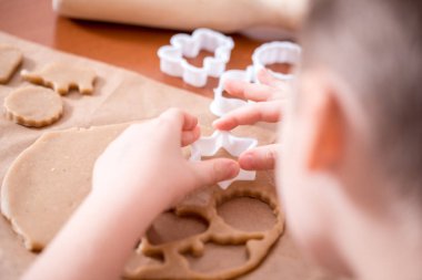 Çocuk el hamur yapmak ve ev yapımı gingerbread çerezleri Noel için pişirin. Gingerbread bir kalp, bir zeus, Noel topları ve hayvan şeklinde. Merry christmas ve yeni yıl kavramı