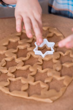 Küçük bir çocuk iken ailesiyle yemek mutfakta kurabiye alarak kapatın. Noel ev yapımı kurabiye. onların test yıldız keser