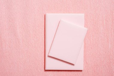 Defter, eskiz defteri veya pembe boş sayfa ve snack - çörek Beyaz ahşap masa üzerinde karalama defteri. Fikirler, notlar, yazma veya kavram çizim planlaması. Üstten görünüm.