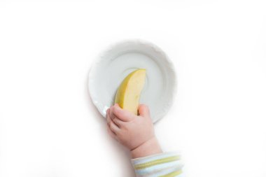 Bebek iki el elma Beyaz ahşap arka plan üzerinde tutun. Küçük bebekler ellerini ve taze meyve üstten görünüm. Düz yatıyordu diyet ve sağlıklı gıda kavramı.