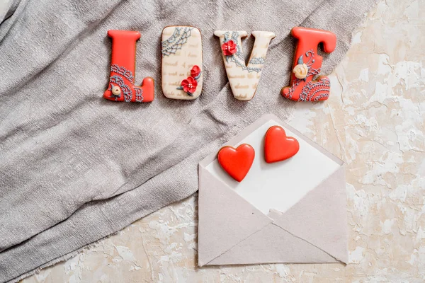 Homemade gingerbread with letters love for Valentines Day located on a dark background, top view