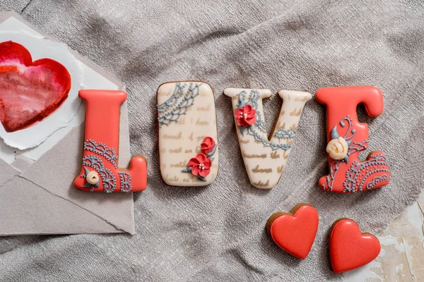 Pan de jengibre hecho en casa con letras de amor para el Día de San Valentín situado en un fondo oscuro, vista superior — Foto de Stock