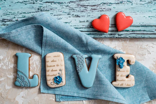 Homemade gingerbread with letters love for Valentines Day located on a dark background, top view