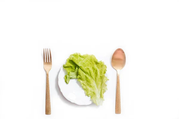 Dieta para bajar de peso. Sobre la plancha blanca, los aparatos de oro - el tenedor y la cuchara — Foto de Stock