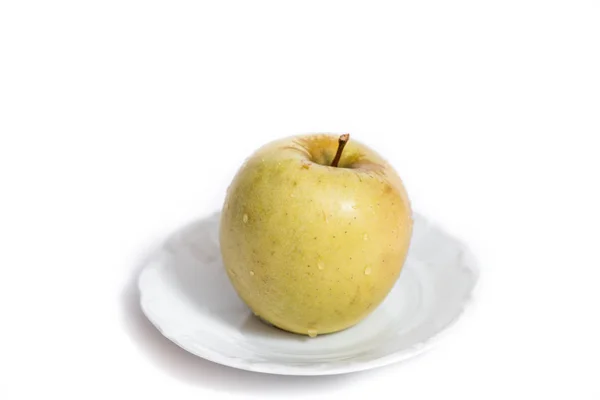 Färskt grönt äpple på en tallrik som isolerad på vit bakgrund — Stockfoto