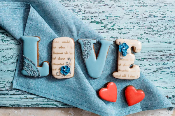 Homemade gingerbread with letters love for Valentines Day located on a dark background, top view