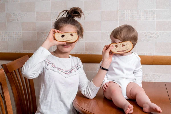Duas Raparigas Brincam Riem Piadas Sorrisos Irmãs Comem Pão Branco — Fotografia de Stock